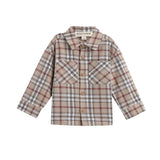 The Mabel + Honey Nicholas Shirt is a long-sleeve plaid flannel button down designed for children, featuring a classic collared neckline, front buttons, and two chest pockets. Crafted from brushed flannel, it showcases beige, brown, and red checkered patterns.