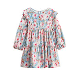 The Mabel + Honey Floral Flutter Dress is a children’s long-sleeve dress featuring a blue base with a pink, red, and white floral print, ruffle shoulders, bishop sleeves, a round neckline, and an enchanting tiered skirt.
