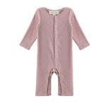 The Mabel + Honey Margret Romper is a long-sleeve, solid heathered pink baby girl romper featuring flower-shaped buttons down the front and along the straight legs, displayed on a white background.