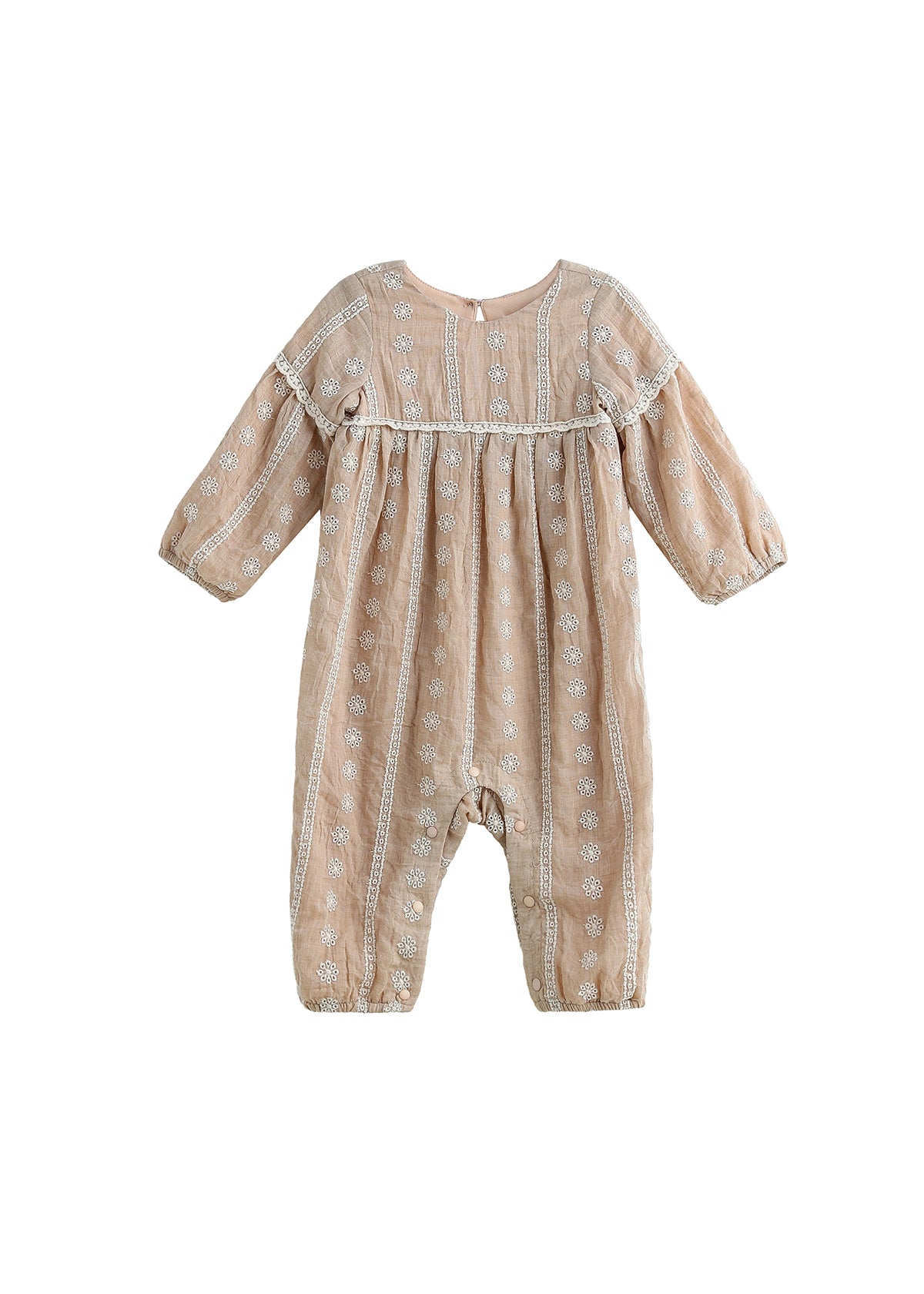 The Patricia Long Sleeve Floral Embroidered Empire Waist Bubble Romper by Mabel and Honey is a light brown baby romper made from a lightweight cotton blend, adorned with delicate white floral embroidery and finished with button closures at the back, shown against a white background.