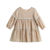 The Patricia Long Sleeve Floral Embroidered Lace Trim Tiered Dress by Mabel and Honey is a light brown children’s dress featuring delicate white floral embroidery, lace trim, and a tiered skirt. Crafted from lightweight cotton, it offers a loose, flowy fit with a round neckline for all-day comfort and charming style.