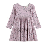 The Victoria Dress Long Sleeve Floral Tiered Ruffle Shoulder Dress by Mabel + Honey is a light purple mauve dress for girls, featuring a small floral print, ruffled shoulder details, and a tiered skirt, displayed on a white background.