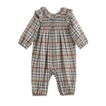 The Mabel + Honey Chestnut Romper is a charming long sleeve bubble romper featuring a plaid pattern in beige, gray, and red. This adorable piece has a smocked bodice, ruffle collar, elastic cuffs at the wrists and ankles for a cozy fit.