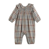 The Mabel + Honey Chestnut Romper is a charming long sleeve bubble romper featuring a plaid pattern in beige, gray, and red. This adorable piece has a smocked bodice, ruffle collar, elastic cuffs at the wrists and ankles for a cozy fit.