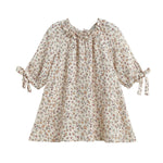 The Mabel and Honey Autumn Breeze Three Quarter Sleeve Floral Ruffle Neck Tie Cuff A Line Dress features a cream-colored floral print, ruffled neckline, gathered collar, and charming bow ties at the cuffs. Designed with a loose, flared silhouette from soft cotton gauze for comfortable wear.