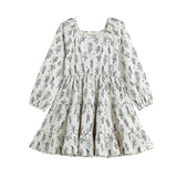 The Gracie Dress Long Sleeve Floral Print Tiered A Line Dress by Mabel + Honey features a white, long-sleeve design with blue wildflower prints, a tiered skirt, square neckline, and a flowy A-line silhouette for girls.