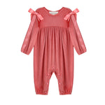 The Mabel + Honey Poppy Rose Romper Long Sleeve Solid Ribbon Tie Bubble Romper features gathered fabric, two pink ribbon bows accenting the shoulders, and convenient snap buttons at the legs. This ribbed knit romper offers a subtle vertical stripe pattern, making it a charming choice for a baby’s fall outfit.