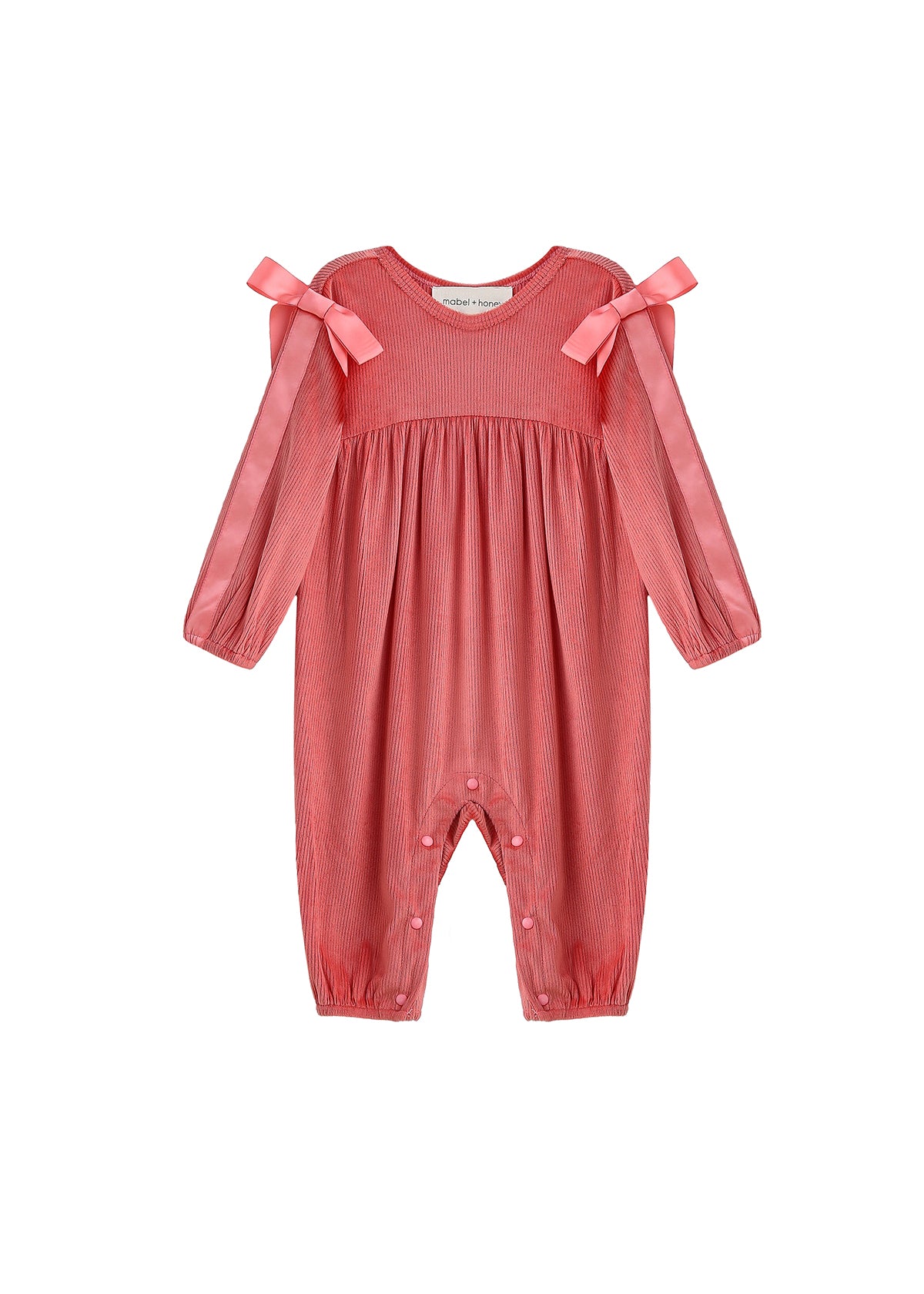 The Mabel + Honey Poppy Rose Romper Long Sleeve Solid Ribbon Tie Bubble Romper features gathered fabric, two pink ribbon bows accenting the shoulders, and convenient snap buttons at the legs. This ribbed knit romper offers a subtle vertical stripe pattern, making it a charming choice for a baby’s fall outfit.
