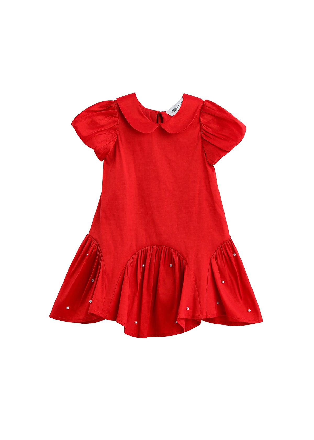 The Mabel + Honey Crimson Glow Dress Puff Sleeve Solid Dropwaist Pearl Embellished Dress is a vibrant holiday red dress for girls, designed with short puff sleeves, a charming Peter Pan collar, and a flared ruffled hem. Pearl embellishments accent the skirt for added elegance. This ruffled girls’ dress is displayed against a plain white background.