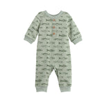 The Matthew Romper Long Sleeve Fish Print Straight Leg Romper by Mabel + Honey is a sage green baby romper featuring long sleeves, a charming hand-drawn fish print, and wooden buttons on the chest. Designed for comfort and convenience, it includes cuffed sleeves and ankles as well as snap closures for easy changing.