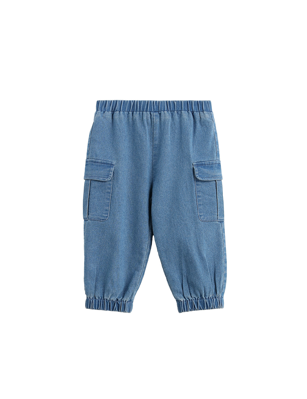 The Michael Pants Solid Chambray Cargo Jogger Style Elastic Cuff Pants by Mabel + Honey are girls’ light denim joggers with a classic cargo design, featuring an elastic waistband and cuffs for comfort. These chambray pants include two large side flap pockets for added utility and are shown laid flat on a white background.