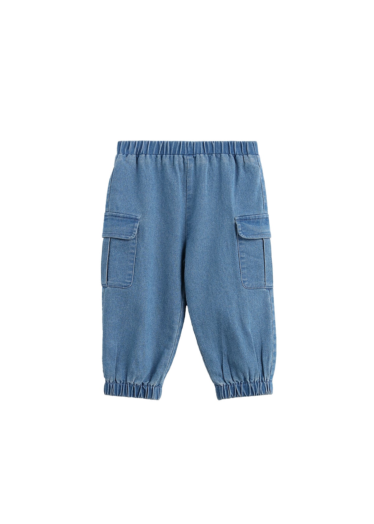 The Michael Pants Solid Chambray Cargo Jogger Style Elastic Cuff Pants by Mabel + Honey are girls’ light denim joggers with a classic cargo design, featuring an elastic waistband and cuffs for comfort. These chambray pants include two large side flap pockets for added utility and are shown laid flat on a white background.