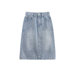 The Rhinestone Embellished Denim Elastic Waist Pencil Skirt from Mabel and Honey is crafted from light blue denim and features a comfortable elastic waistband, front button and zipper closure, belt loops, pockets, subtle distressing with small faded spots throughout the fabric, and stylish rhinestone embellishments. Displayed on a plain white background.
