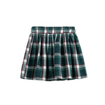 The Evergreen Skirt Plaid A Line Skirt by Mabel + Honey features a short, pleated design with a green, white, and red plaid pattern. Crafted from cozy flannel-weight fabric and finished with an elastic waistband, it’s perfect for festive holiday outfits. Shown on a white background.