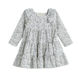 The Mabel + Honey Doggie Doodles Dress Long Sleeve Print Tiered Dress features a light gray fabric adorned with a charming black outline dog print. Designed with playful ruffles on the shoulders and a tiered skirt, this girls’ fall dress is perfect for little animal lovers.