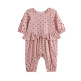 Dress your little one in the Mabel + Honey Love me Lots Romper Long Sleeve Heart Print Ruffle Waist Romper—featuring a playful pink design with red heart prints, ruffle details at the waist, and elastic cuffs at the wrists and ankles. This adorable piece is perfect for girls as a Valentine’s Day outfit!.