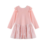 The Blushing Velvet Dress Long Sleeve Solid Sequin Skirt Party Dress by Mabel + Honey is a light pink girls’ party dress with ruffled shoulders and a shimmery sequined skirt. This charming piece features a sequin overlay, a round neckline, and is beautifully displayed against a white background.