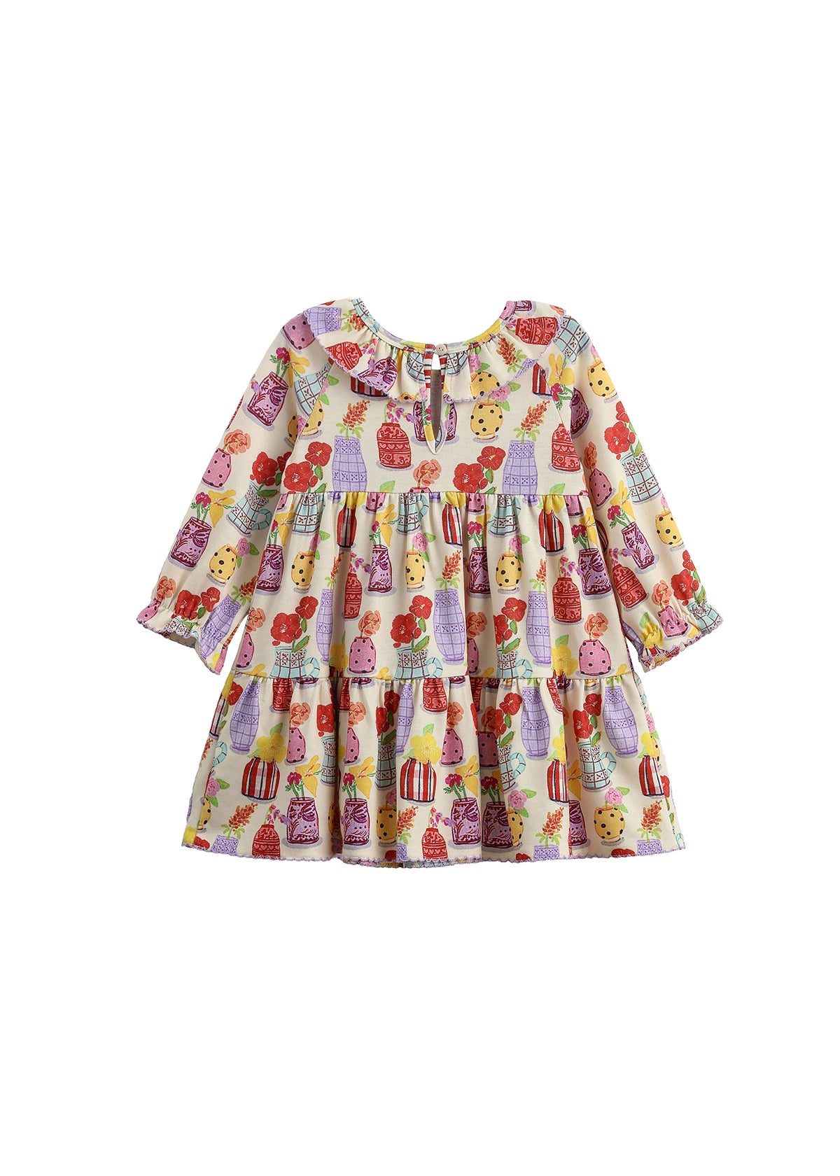 The Petal Pots Long Sleeve Print Ruffle Collar Tiered Dress by Mabel and Honey features a soft cream stretch knit fabric, a relaxed fit, and playful tiered layers. Adorned with a vibrant pattern of cupcakes, candies, bows, and touches of floral print in red, purple, and yellow, this toddler dress is finished with long sleeves and a charming ruffled collar. Displayed on a white background.