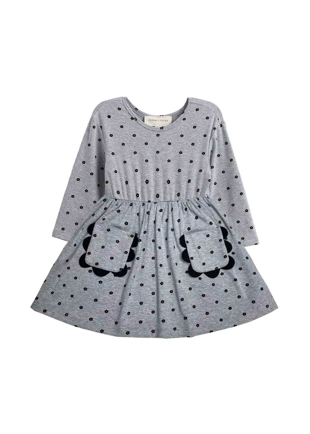 The Mabel and Honey Petal Pockets Long Sleeve Floral Scalloped Pocket A Line Dress features a gathered waist, two front pockets with scalloped trim, and a classic round neckline. Designed for children, this comfortable knit dress showcases a charming floral pattern.