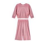 The Bowtiful Blush Long Sleeve Solid Bow Tie Side Slit Top and Pant Set by Mabel and Honey is a kids’ blush two-piece outfit featuring a pink ribbed knit top with long sleeves and delightful bow tie side slit details, paired with coordinating wide leg pants, displayed on a white background.