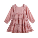 The Rosie Posie Long Sleeve Gingham Tiered Ruffle Dress by Mabel and Honey features a pink and white checkered pattern, long sleeves, a square neckline, and multiple ruffled tiers with playful ruffle trim. Shown against a white background, this lightweight cotton dress combines comfort with timeless charm.