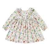 The Cactus Kisses Dress Long Sleeve Print Ruffle Trim A Line Dress by Mabel and Honey features a white long-sleeve design with a ruffled neckline and a playful western-themed print of cacti, cowboy boots, hats, horseshoes, and stars.