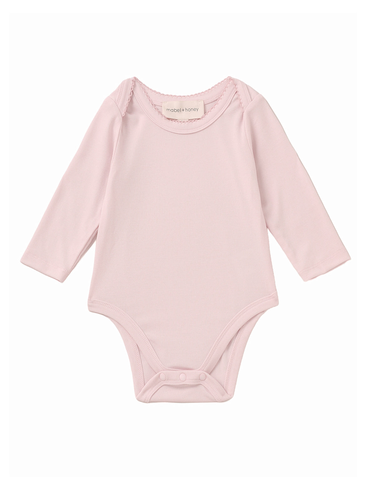 The Mabel and Honey Whimsical Wildflower Long Sleeve Solid Scalloped Trim Snap Bottom Bodysuit is shown on a plain white background, featuring a light pink color, round neckline, long sleeves, scalloped trim details, and convenient snap closures at the bottom. Crafted from soft Tencel knit for gentle comfort.