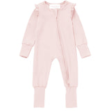The Amelia Rose Convertible Romper by Mabel + Honey is a light pink, long-sleeve baby girl romper featuring ruffle trim on the shoulders, a front zipper, and ribbed cuffs at the sleeves and legs. The footed garment is displayed laid flat on a white background.