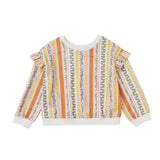 The Mabel and Honey Buttercup Blossom Sweater is a colorful long-sleeve pullover featuring vertical floral and geometric stripes in orange, green, red, and white. This vintage-inspired sweater is designed with charming ruffle details on the shoulders and finished with crisp white cuffs at the sleeves and hem.