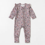 The Mabel + Honey Soft Meadow Convertible Romper features long sleeves and ruffle shoulders, adorned with a pink and purple wildflower print from the Soft Meadow Collection, shown laid flat on a white background.