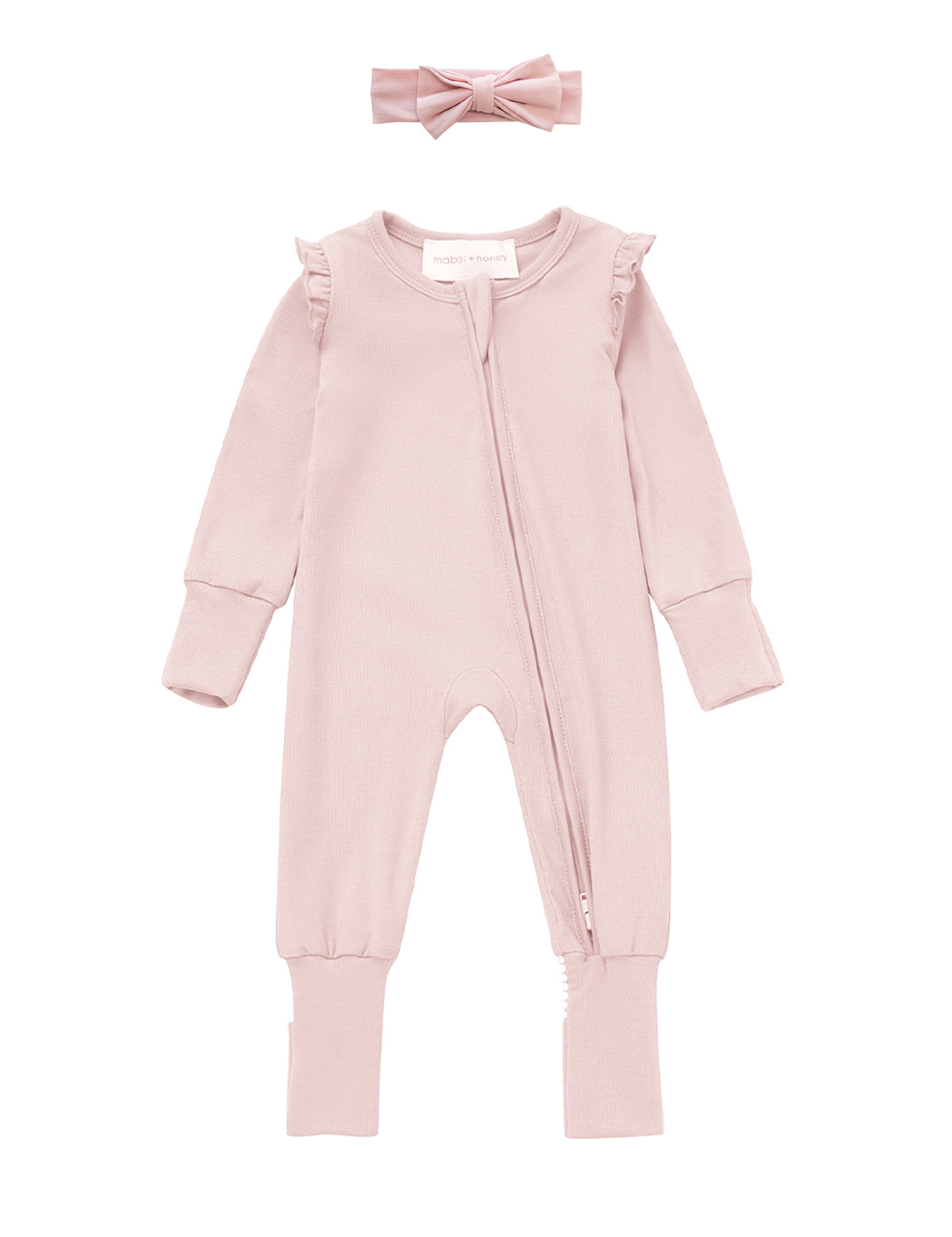Introducing the Whimsical Wildflower Convertible Romper with Headband from Mabel + Honey—a soft light pink baby romper featuring long sleeves, ruffled shoulders, a diagonal zipper, and a convertible footed sleeper design for versatility and comfort. The set includes a matching pink fabric headband adorned with a bow displayed above the outfit.