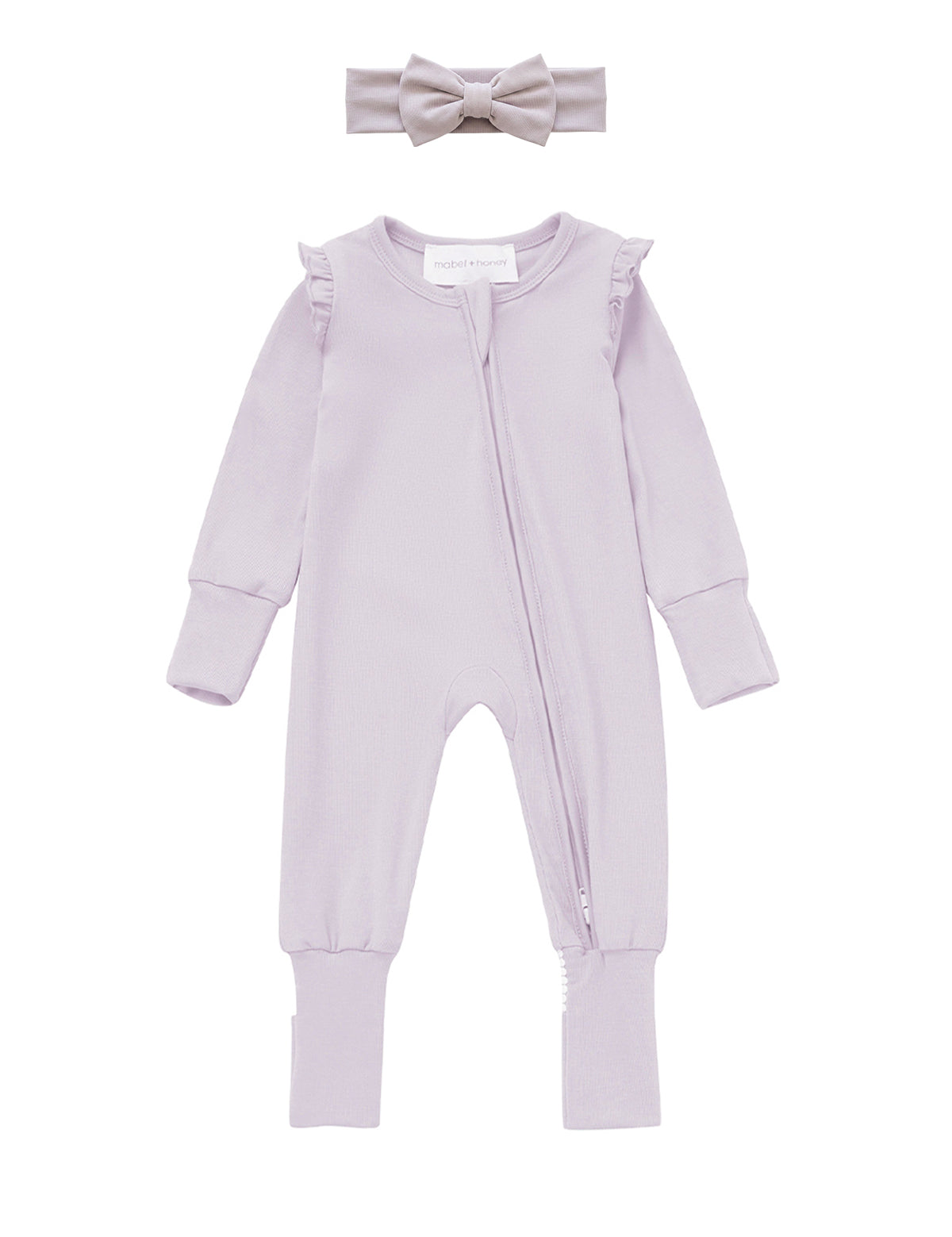 The Mabel + Honey Soft Meadow Convertible Romper features soft tencel knit in a light purple long-sleeve design with ruffle shoulders and a convenient front zipper. This solid convertible romper comes paired with a matching headband topped with a sweet bow, creating an adorable, coordinated look for your baby girl.