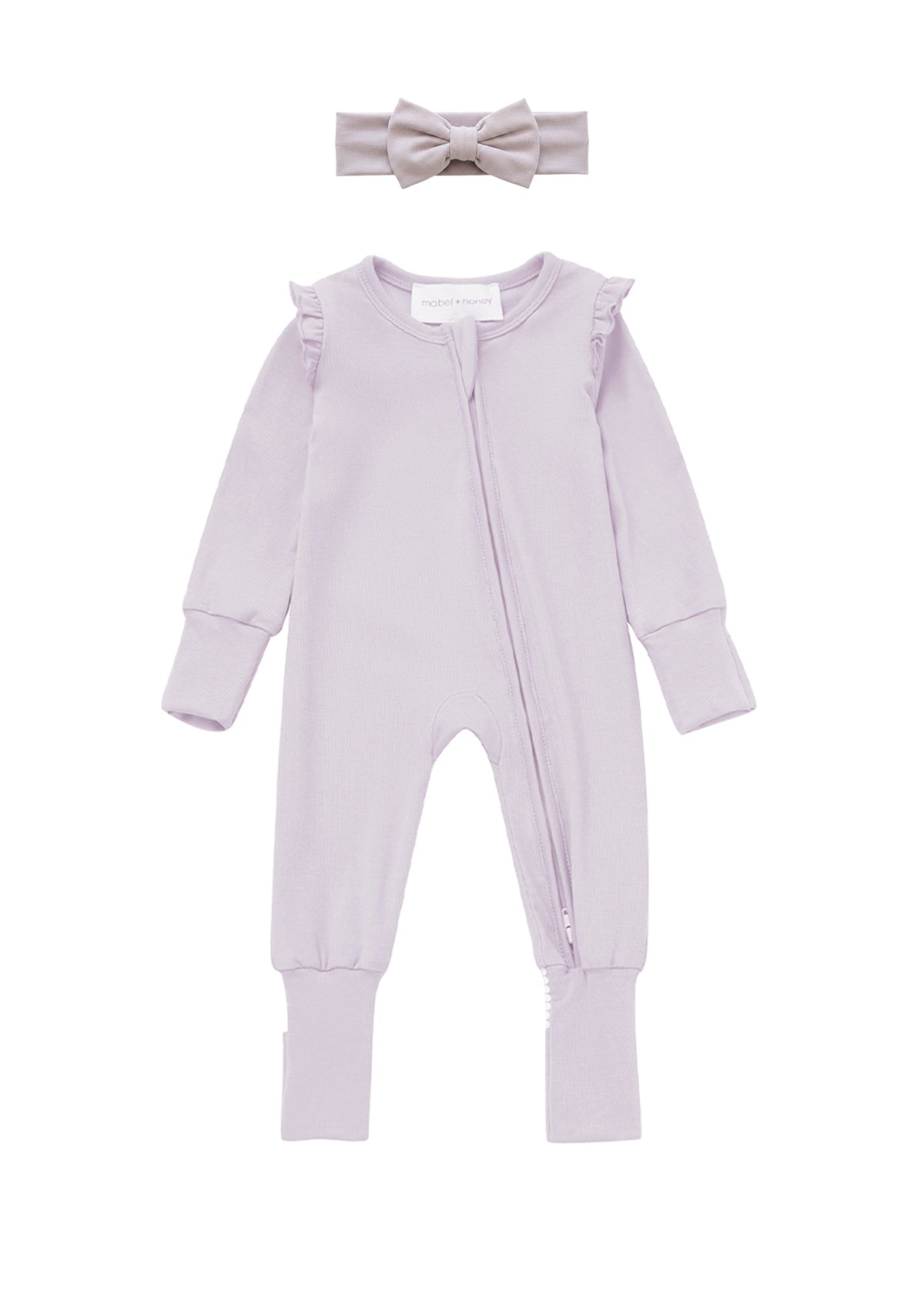 The Mabel + Honey Soft Meadow Convertible Romper features soft tencel knit in a light purple long-sleeve design with ruffle shoulders and a convenient front zipper. This solid convertible romper comes paired with a matching headband topped with a sweet bow, creating an adorable, coordinated look for your baby girl.