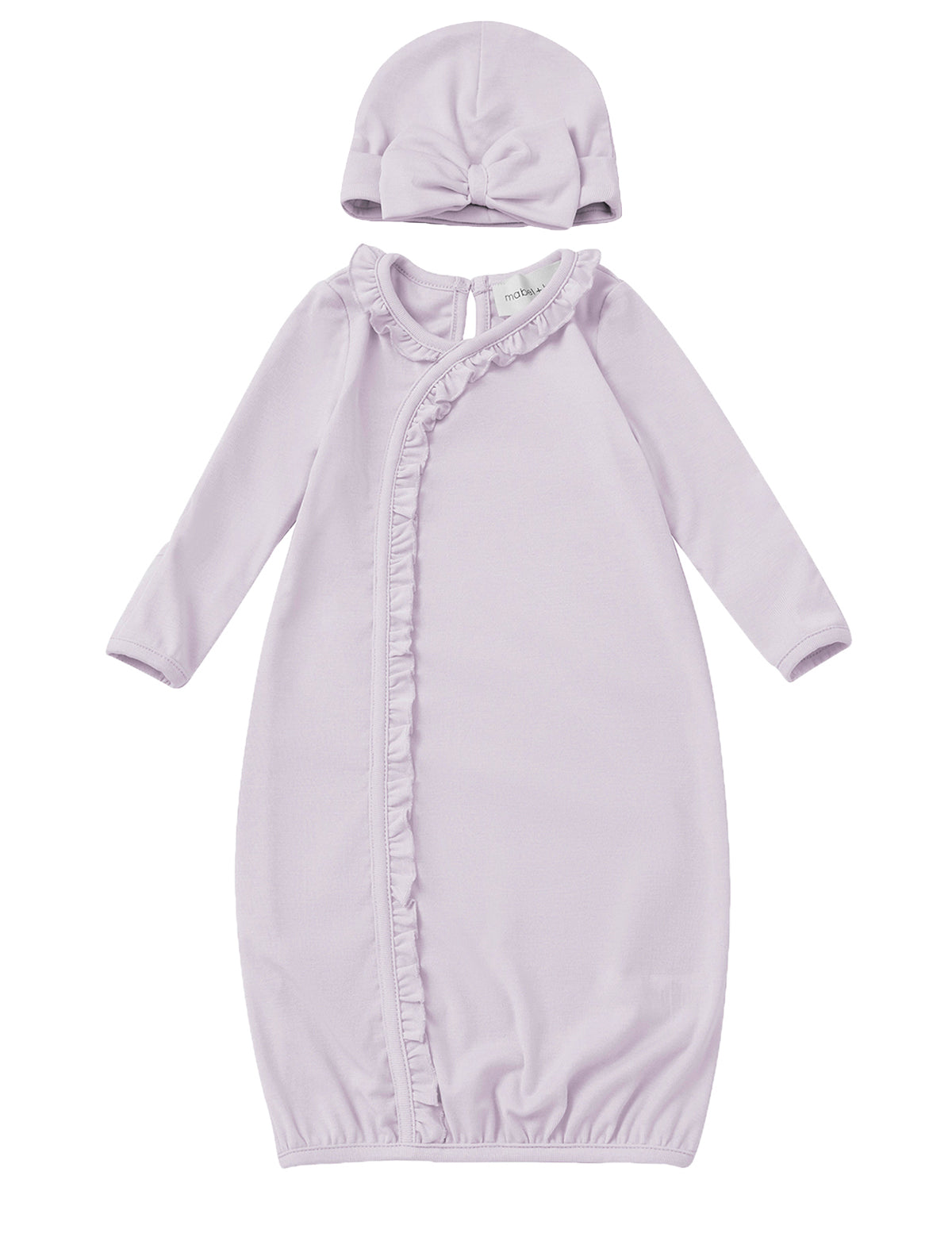 The Soft Meadow Newborn Gowns Long Sleeve Solid Gown with Matching Hat by Mabel + Honey features a lilac gown with ruffle trim along a diagonal front closure and an elasticized hem for easy changes. The set includes a matching hat accented with a front knot detail. Both pieces are crafted from soft fabric and are displayed on a white background.