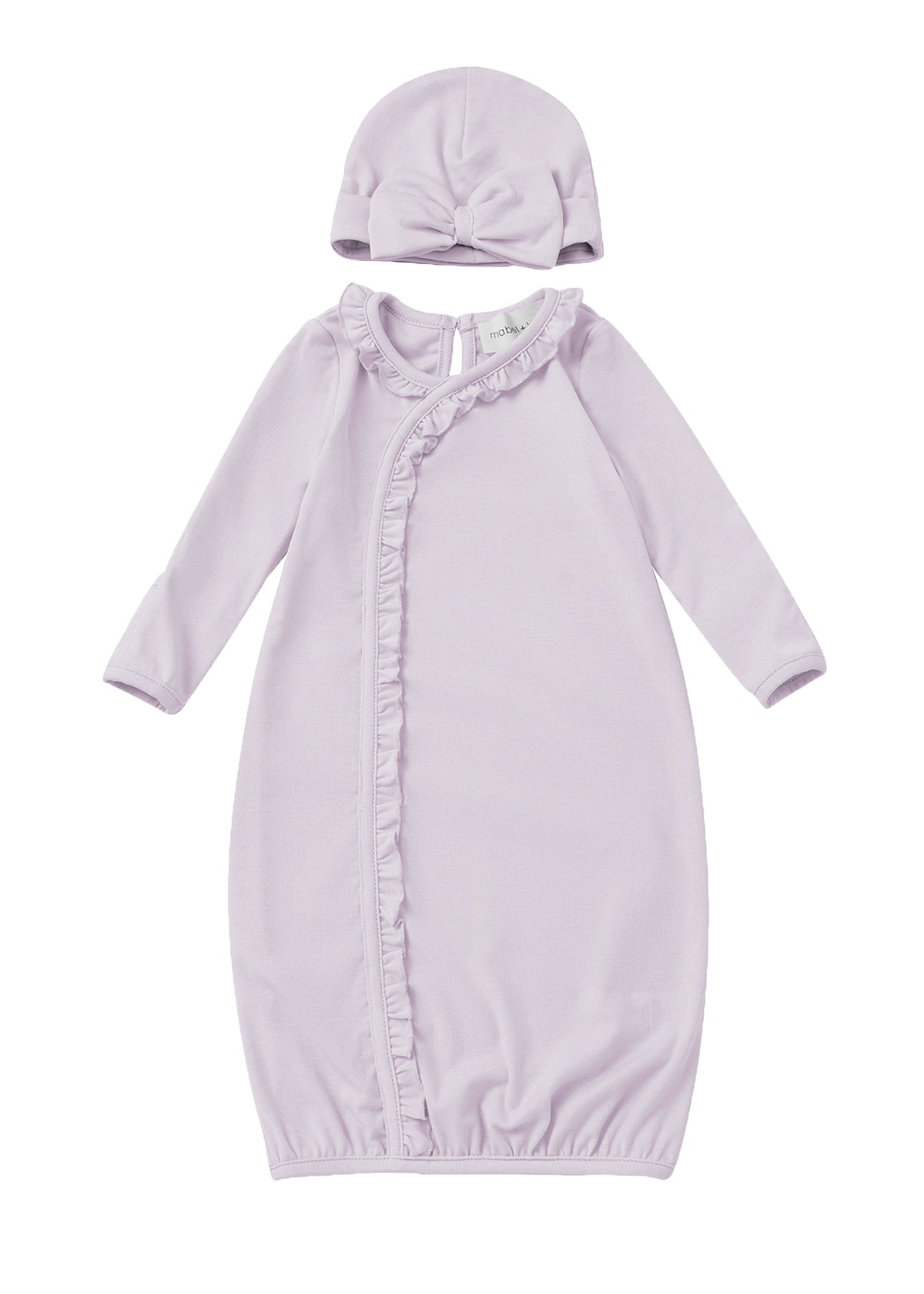 The Soft Meadow Newborn Gowns Long Sleeve Solid Gown with Matching Hat by Mabel + Honey features a lilac gown with ruffle trim along a diagonal front closure and an elasticized hem for easy changes. The set includes a matching hat accented with a front knot detail. Both pieces are crafted from soft fabric and are displayed on a white background.