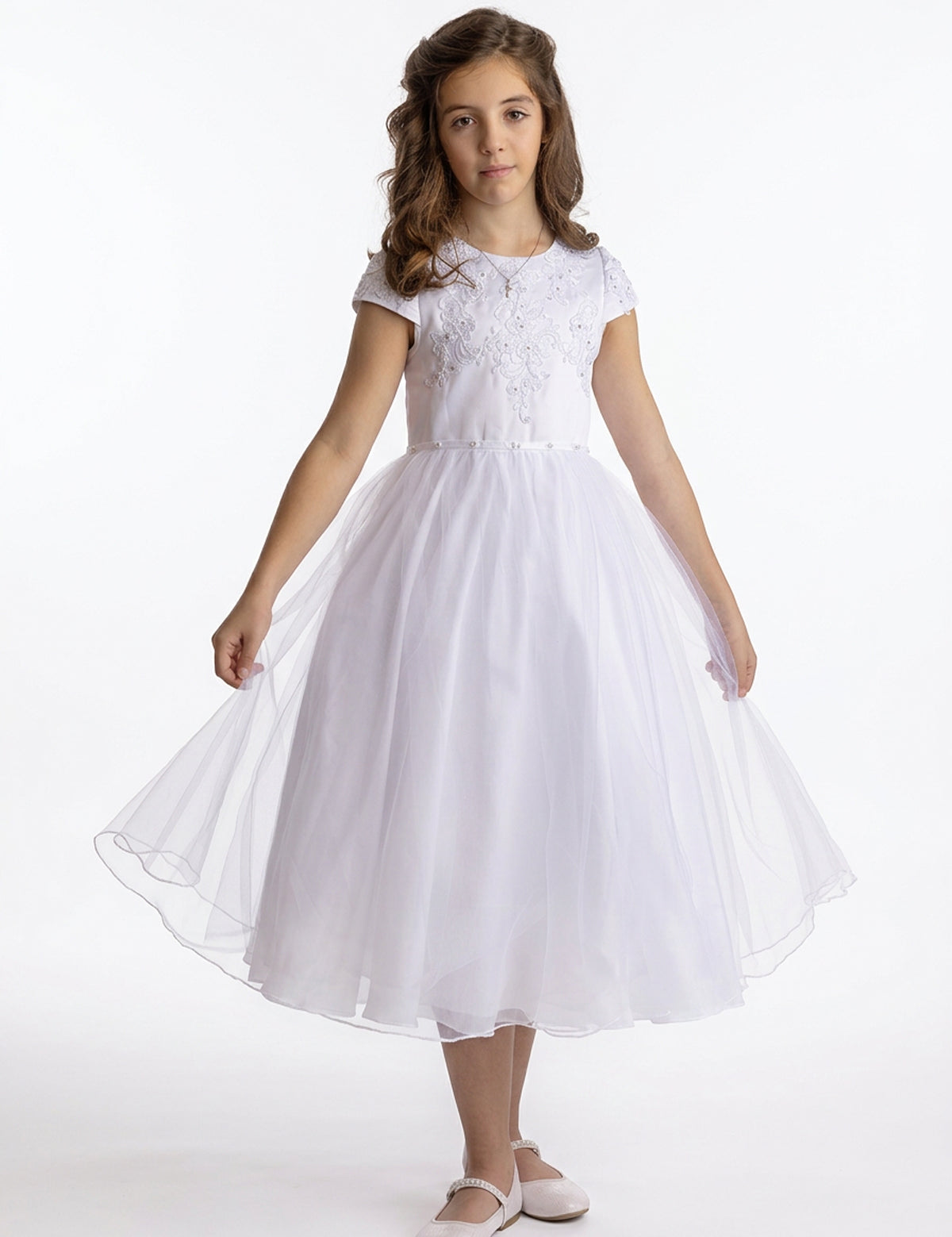 A girl wearing a Lauren Marie Satin Beaded Lace Bodice Dress with a white beaded lace bodice and a flared tulle skirt, holding the hem out to the sides.