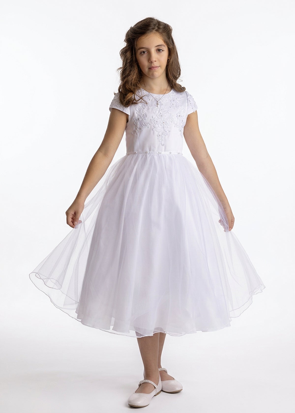 A girl wearing a Lauren Marie Satin Beaded Lace Bodice Dress with a white beaded lace bodice and a flared tulle skirt, holding the hem out to the sides.